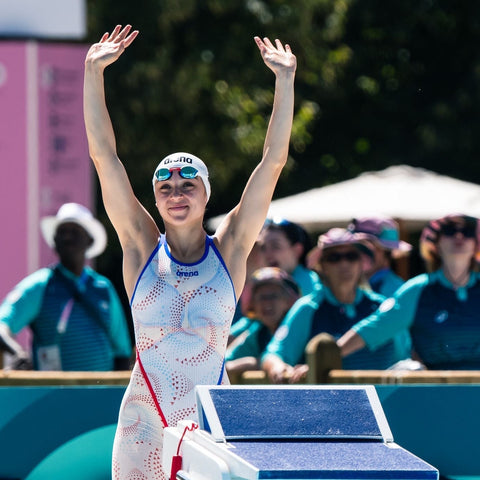 Anna Jurt, Olympiateilnehmerin im Modernen Fünfkampf, winkt vor dem Schwimmwettkampf dem Publikum zu